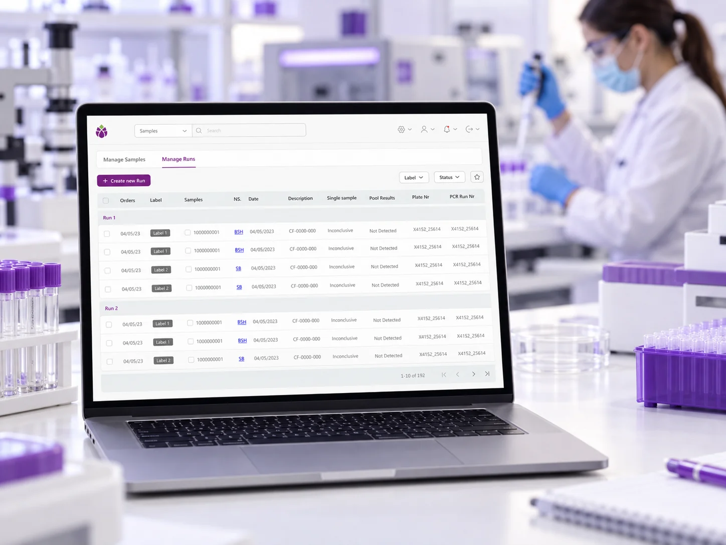 Artichoke Manage Runs screen on a laptop in a laboratory, with sample tubes and a lab technician